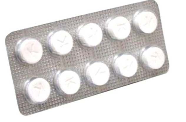 Blister de pilules blanches avec la lettre 'K' sur chacune. Le fond est blanc.