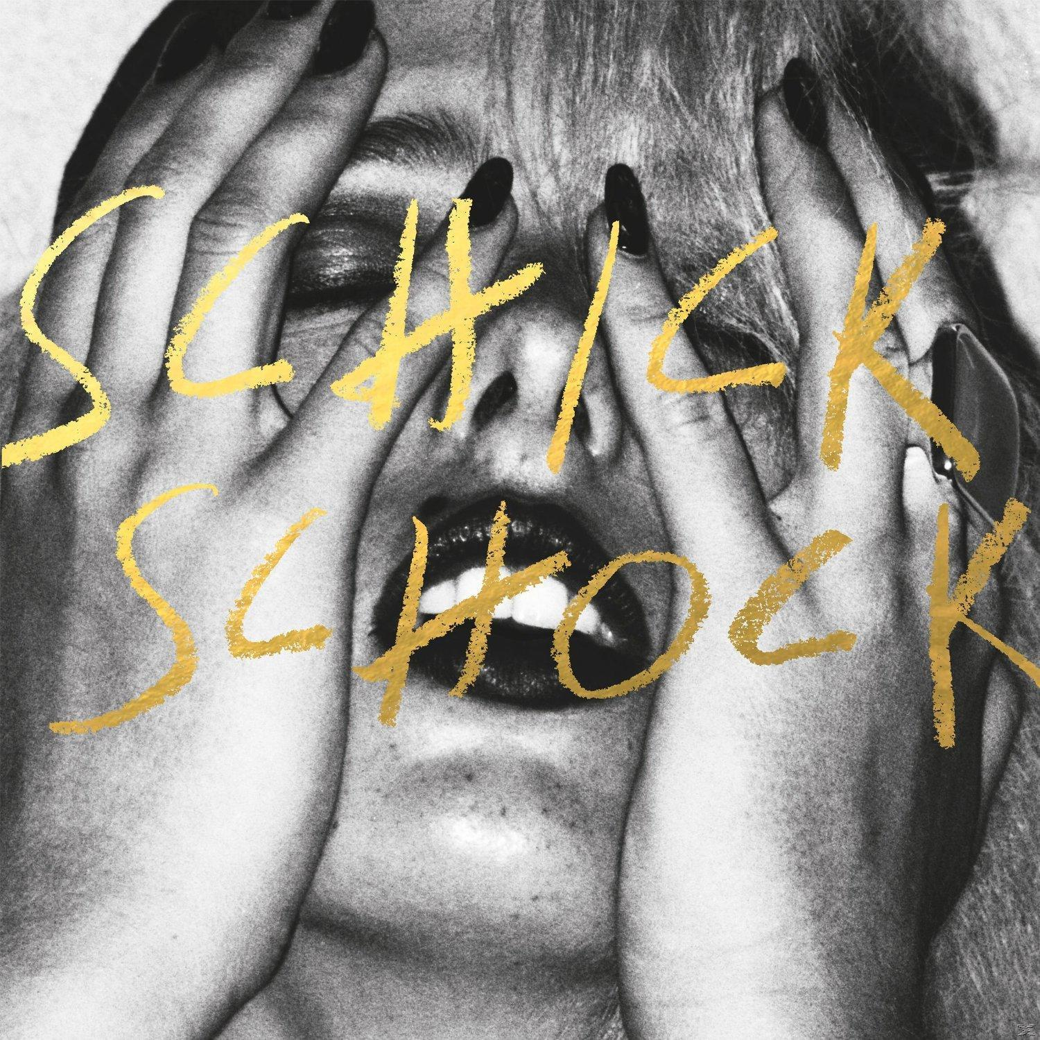 Albumcover 'Schick Schock' zeigt eine Frau, die ihr Gesicht verdeckt, mit goldenem Text.