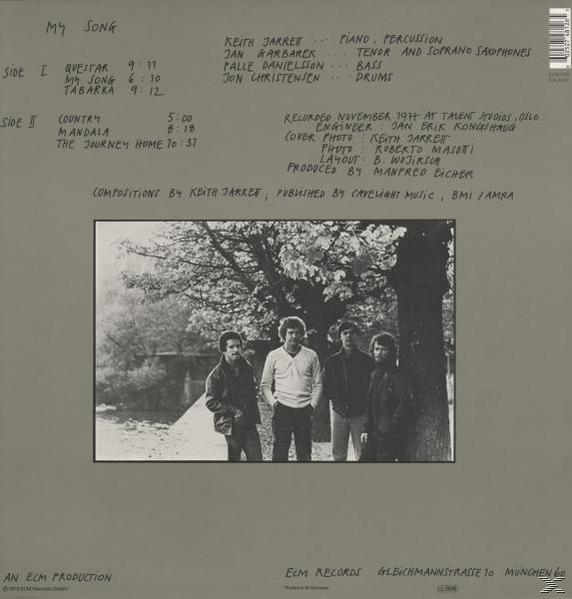 Albumcover mit Text, Bandmitgliedern in der Mitte und einem Baum im Hintergrund.