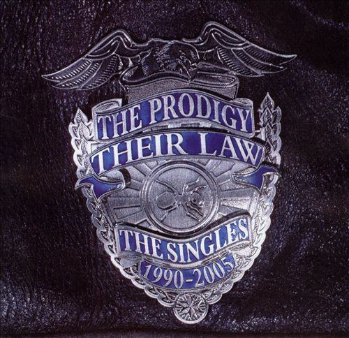 Album borító: The Prodigy 'The Singles' jelvénye bőrön. Ezüst, kék és fehér színek használatosak.