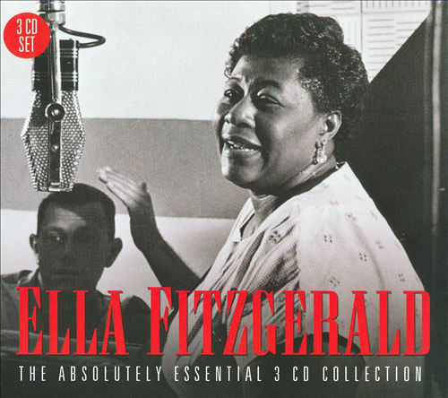 Ella Fitzgerald mikrofonba énekel, a háttérben egy személy.
