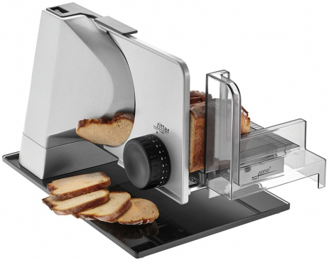 Ein Brotschneider mit Brot, das geschnitten wird, und Scheiben auf schwarzem Untergrund.