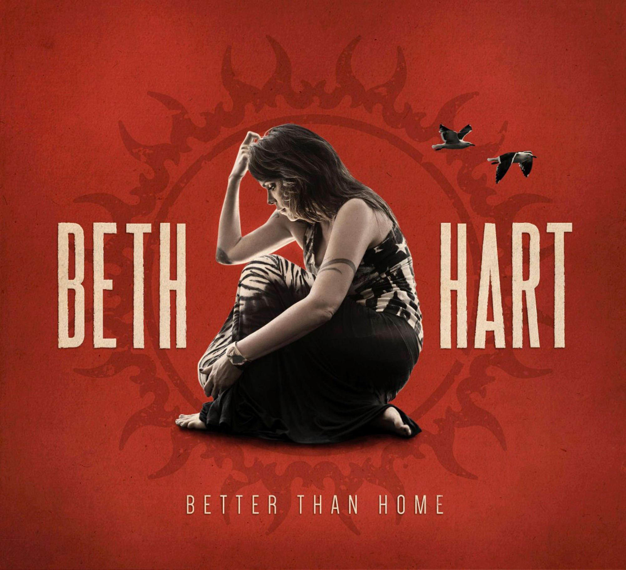 Albumcover. Beth Hart sitzt, Hand am Kopf, mit fliegenden Vögeln. Roter Hintergrund mit sonnenähnlichem Design und den Worten 'Beth Hart'.
