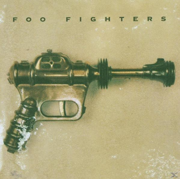 Foo Fighters Albumcover mit einer futuristischen Waffe auf beigem Hintergrund.