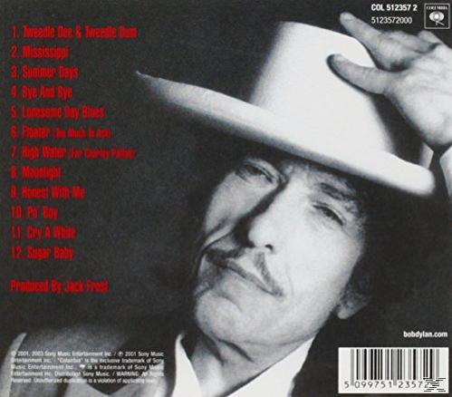 Albumcover von Bob Dylan mit Hut. Songtexte im Hintergrund.