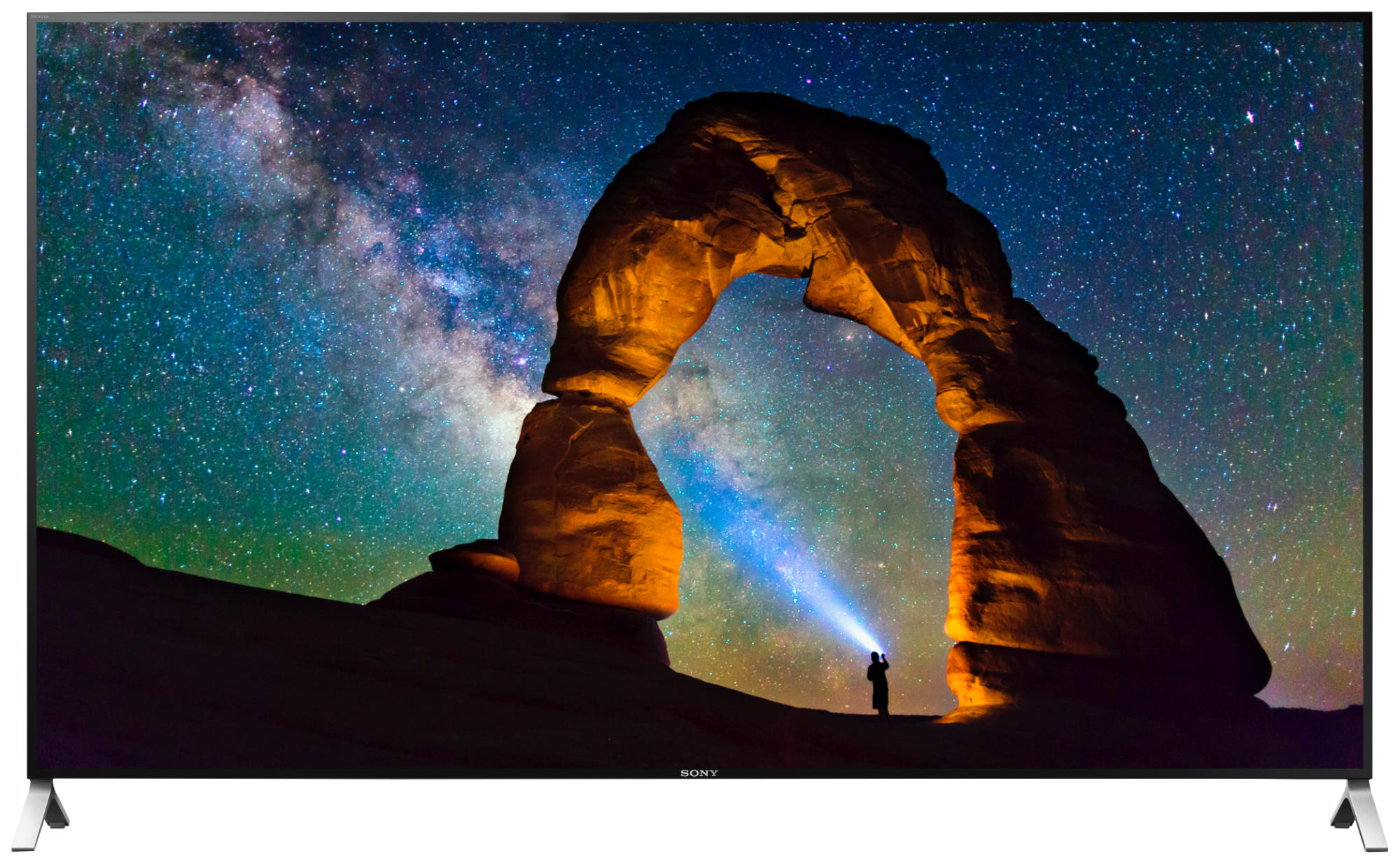 Una pantalla ancha muestra un cielo nocturno estrellado con una persona usando una linterna en un arco.