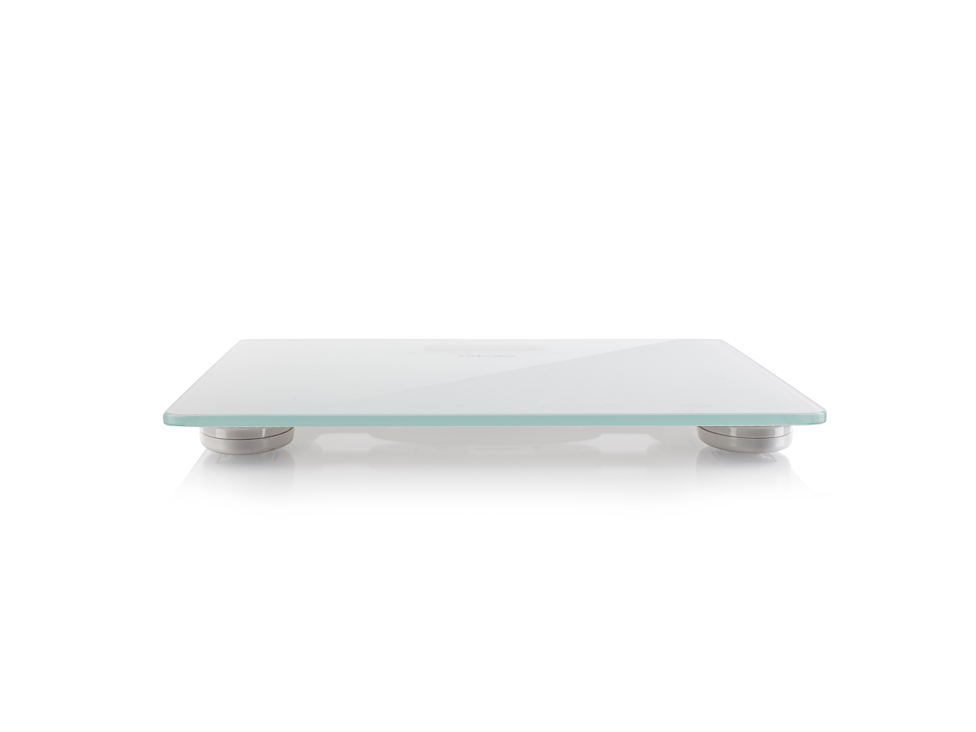 Eine flache Waage mit Glasoberfläche und silbernen Füßen, auf weißem Untergrund.