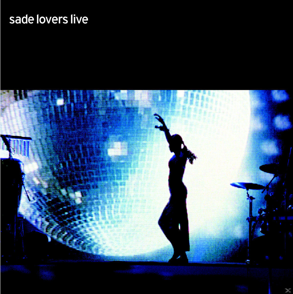 Silhouette einer Frau, die auf der Bühne tanzt. Großer Bildschirm im Hintergrund mit Lichteffekten. Text: sade lovers live.