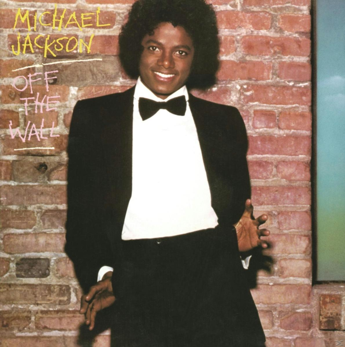 Michael Jackson fekete öltönyben és csokornyakkendőben mosolyog. A 'Off The Wall' albumcím fölötte látható.