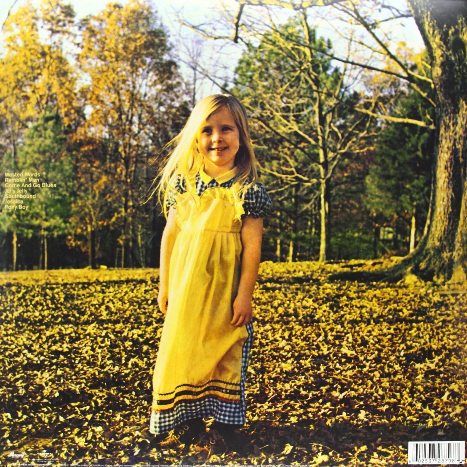 Albumcover mit einem kleinen Mädchen in einem gelben Kleid, das in einem Feld mit Herbstlaub steht.