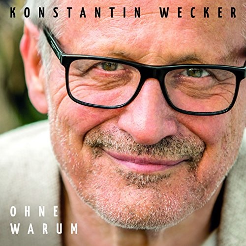 Albumcover mit Nahaufnahme eines älteren Mannes mit Brille und Text.