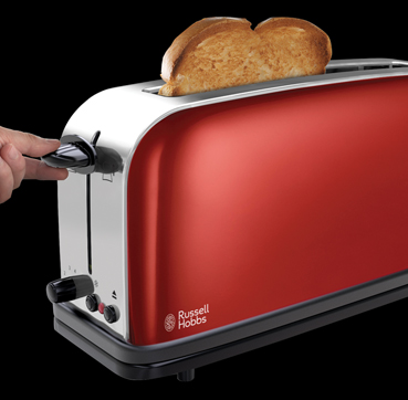 Red toaster with two slices of toasted bread, a hand is adjusting the darkness setting.