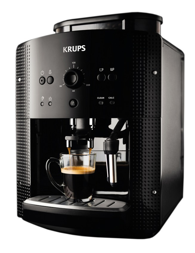 Een zwarte KRUPS espressomachine zet koffie in een glazen kopje. Machine heeft knoppen en een draaiknop. Koffie giet.