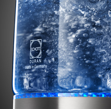 Close-up of a glass kettle with boiling water inside. The Schott Duran logo is visible.