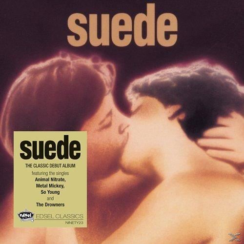 Albumcover von Suede, ein küssendes Paar. Ein gelber Aufkleber links lautet The Classic Debut Album.