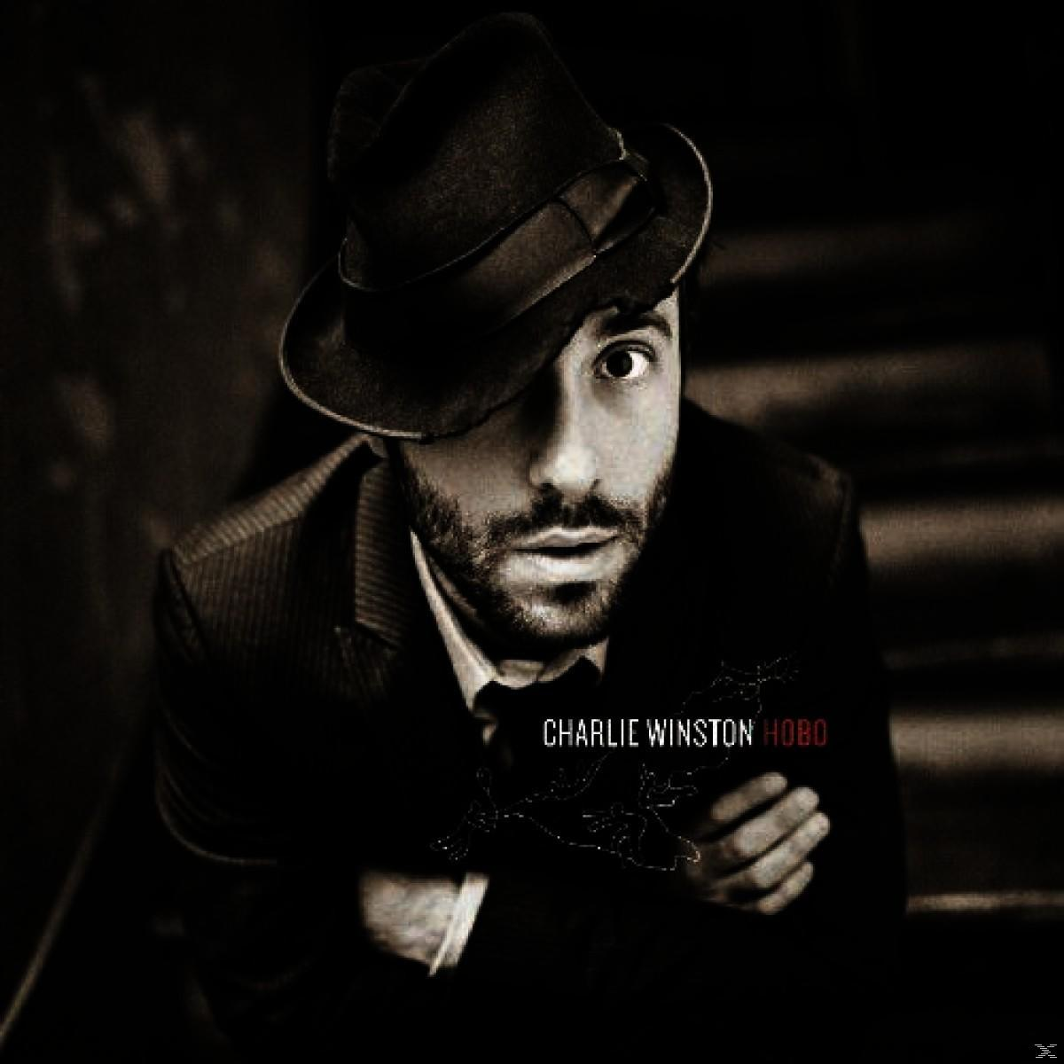 A Charlie Winston 'Hobo' albumának borítója. Férfi kalapban, öltönyben, felfelé néz. Szöveg: Charlie Winston, Hobo.