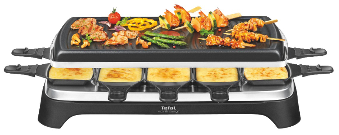Un grill à raclette noir avec une surface de cuisson et des poêles, chargés de nourriture. Fond blanc.