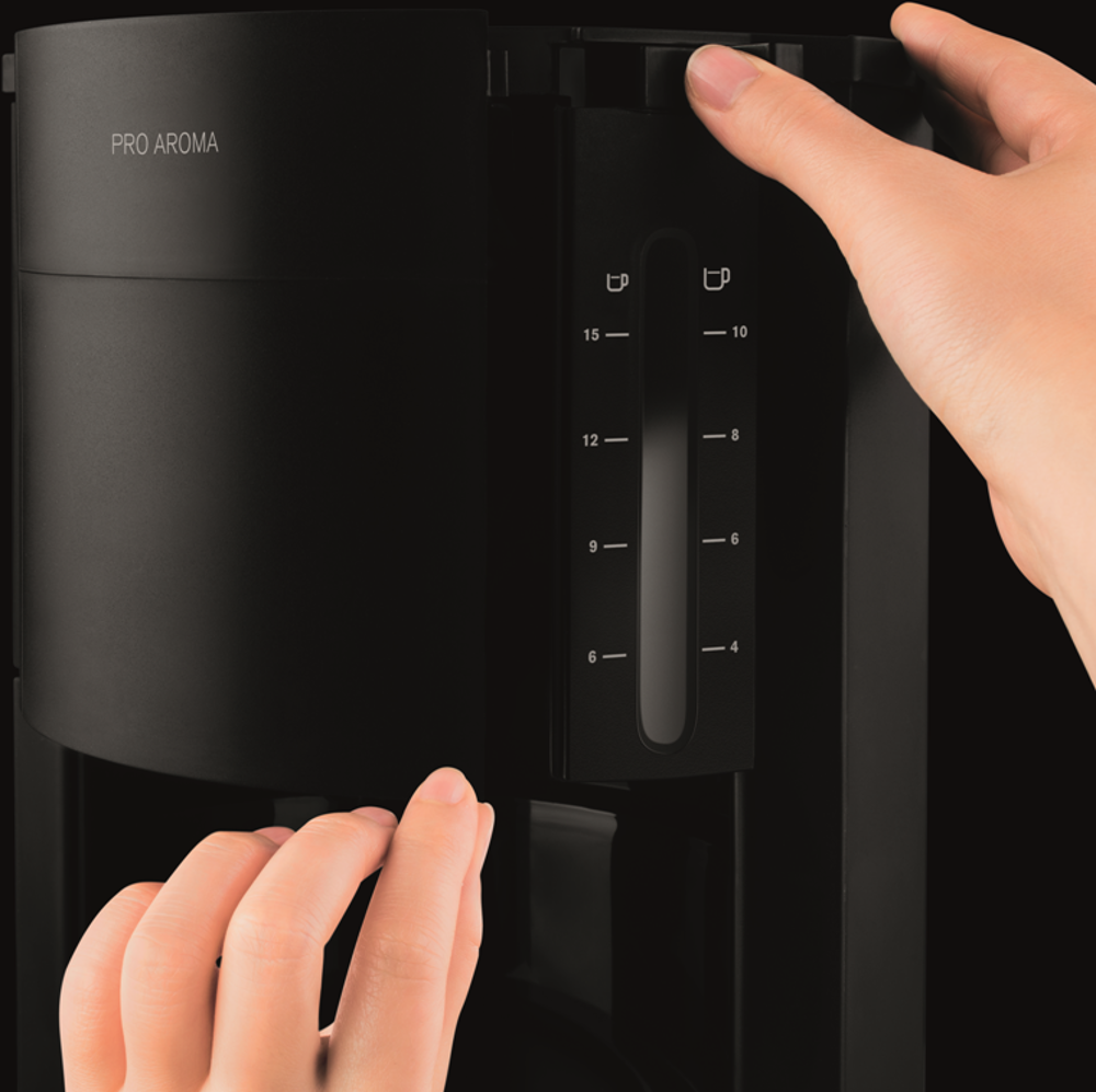 Hände, die den Wasserstand der Kaffeemaschine einstellen, schwarze Maschine, schwarzer Hintergrund.
