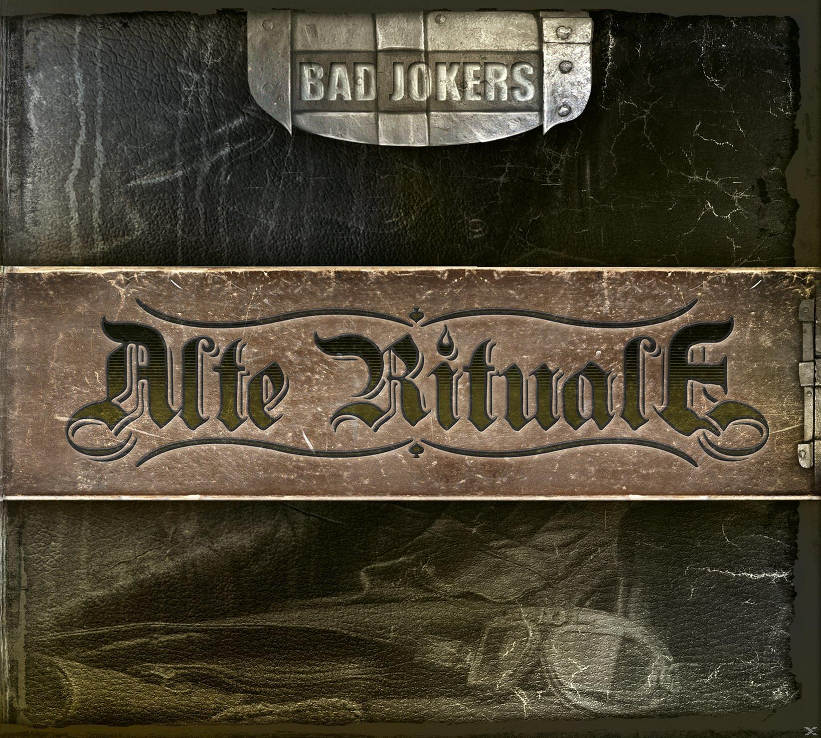 Ein Buchcover mit dem Titel 'Alte Rituale', mit einem Metallverschluss, der 'BAD JOKERS' sagt.