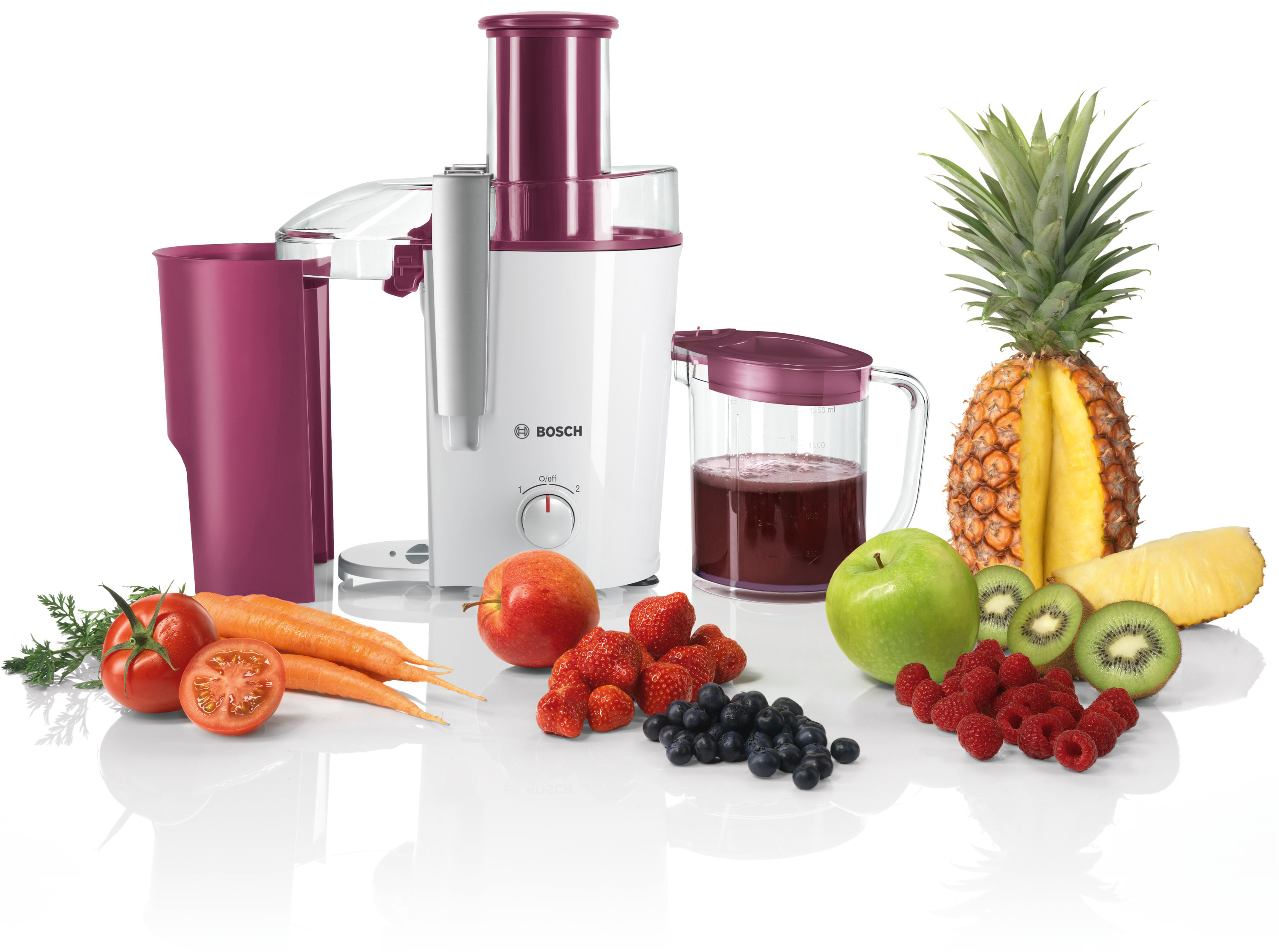 Entsafter mit Obst und Gemüse drumherum, auf weißem Hintergrund.