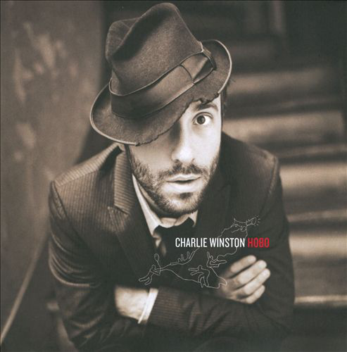 Album borító: Egy férfi fedora kalapban, karba tett kézzel, lépcsők a háttérben. Szöveg: Charlie Winston.