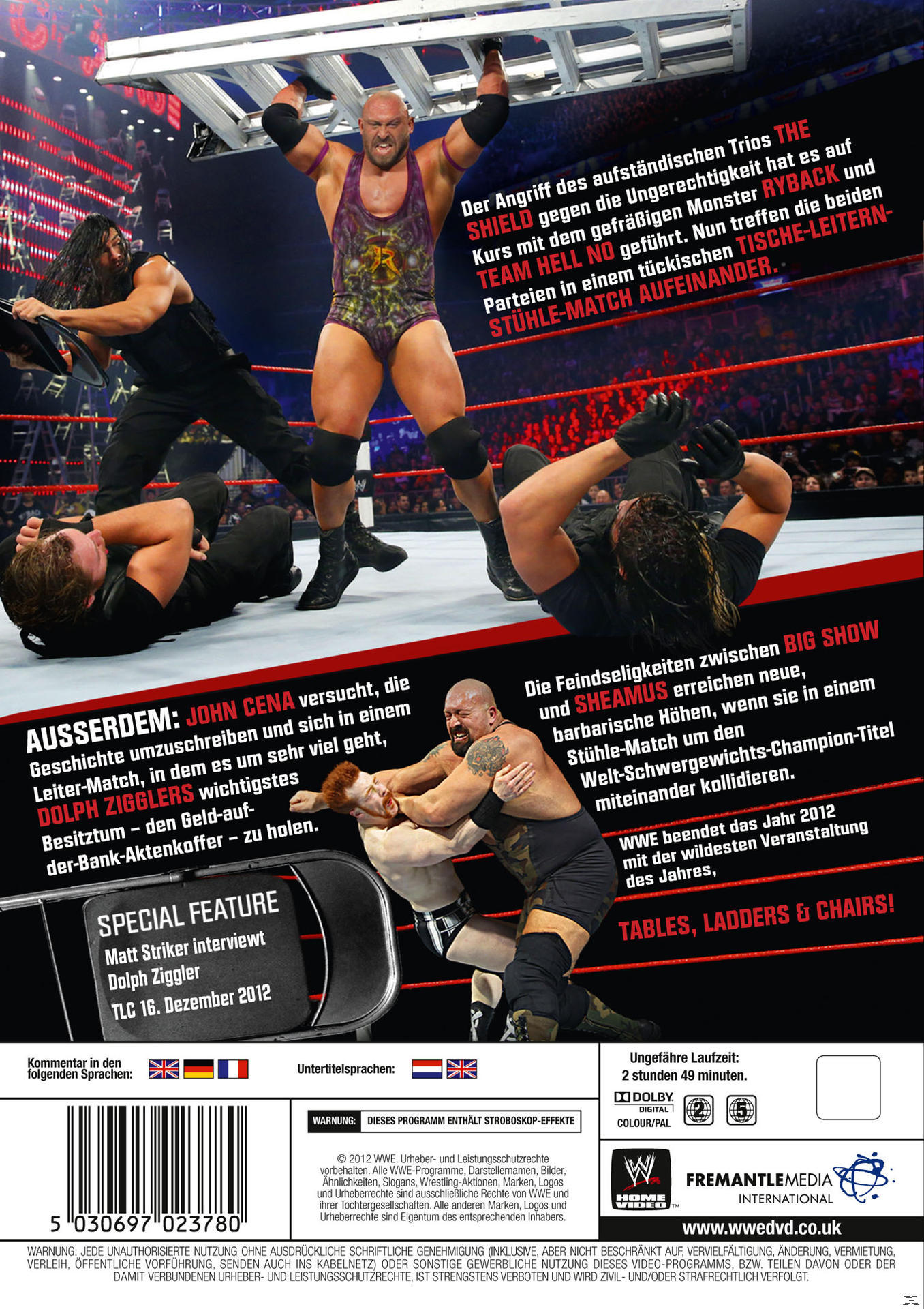 Wrestler im Ring, Actionaufnahme, Publikum im Hintergrund, helles Licht.