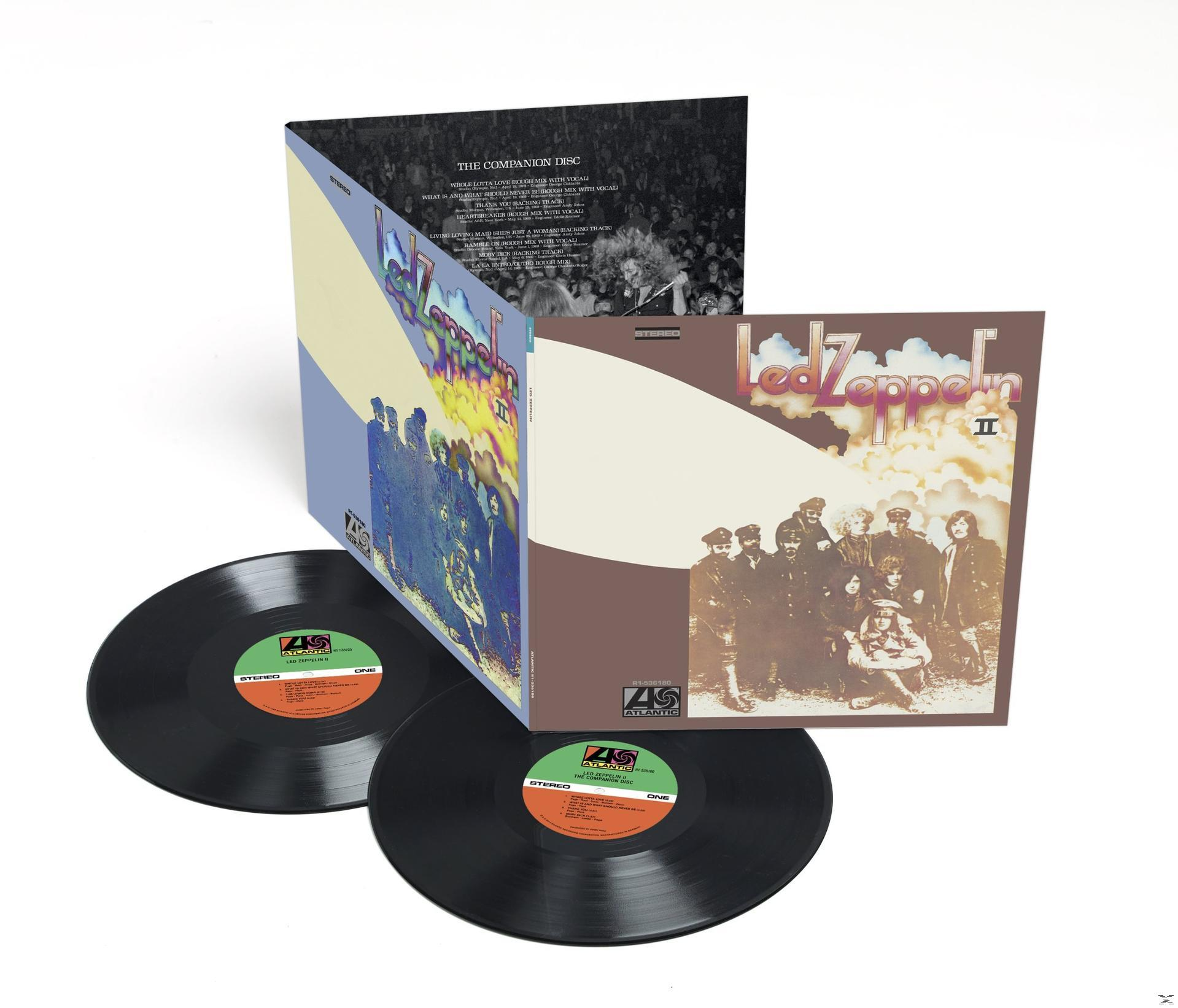 Led Zeppelin II album borítója a kísérő lemez borítója előtt, bakelitlemezek láthatók.
