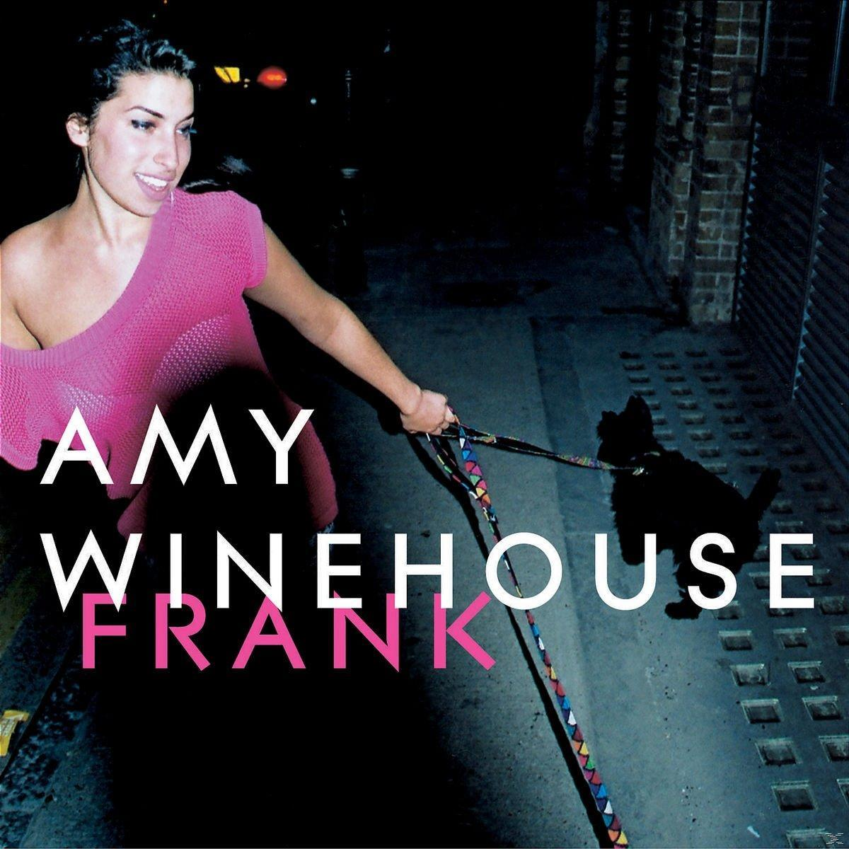 Amy Winehouse promenant un chien dans la rue.