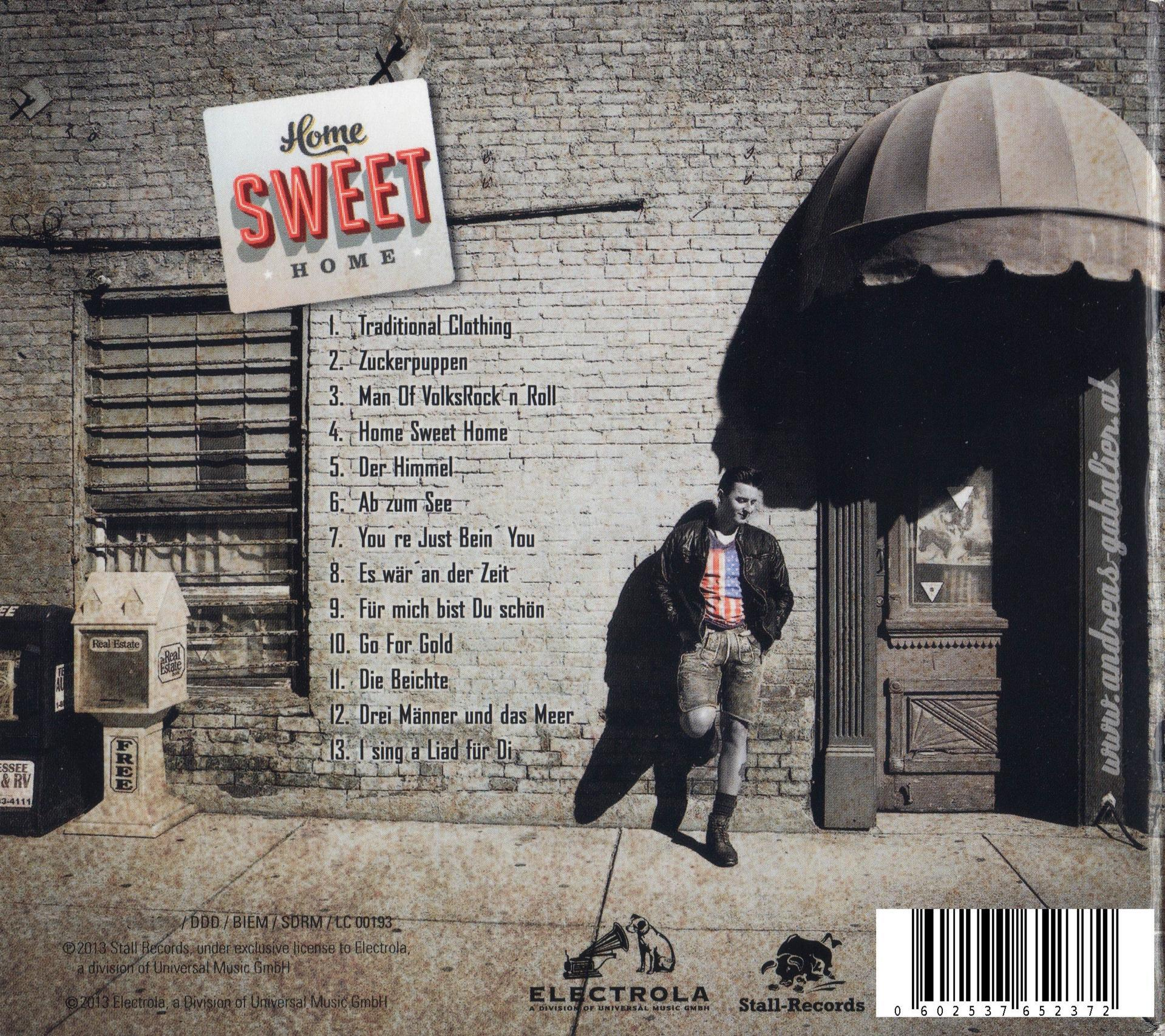 Albumcover. Ein Mann an einer Backsteinmauer mit einer Titelliste. Eine Tür und ein Gebäude.