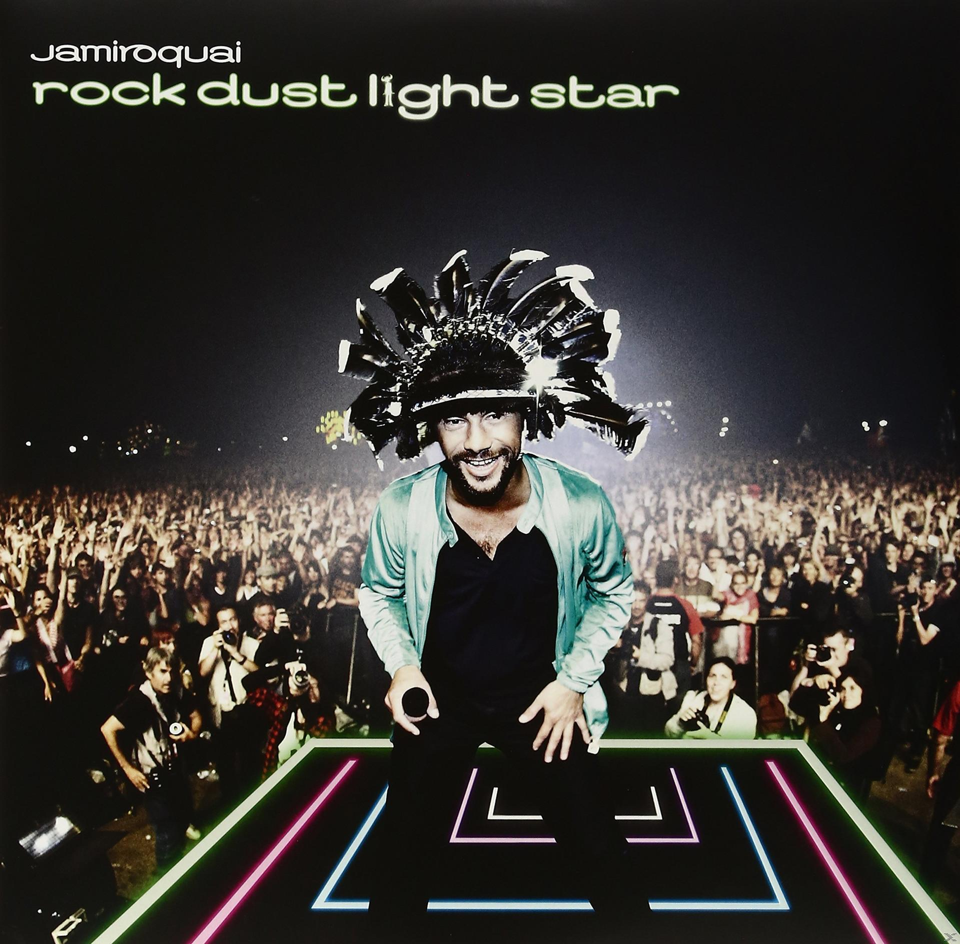 Élő koncert. Jamiroquai a színpadon, kalapot viselve. Tömeg a háttérben.