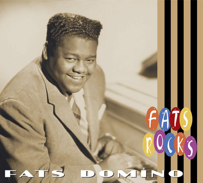 Öltönyös férfi mosolyog és zongorázik, a 'Fats Rocks' felirattal.