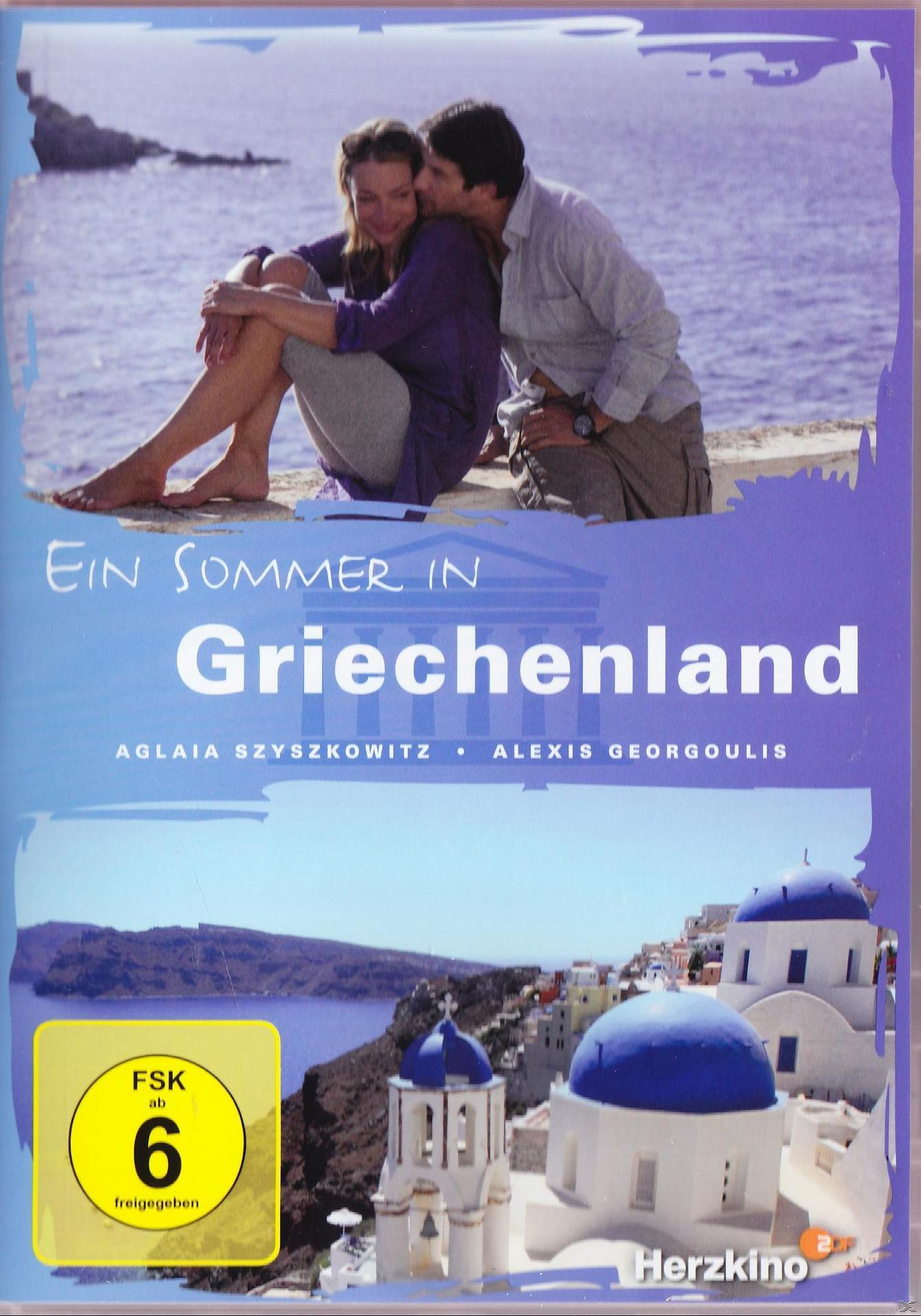 DVD-Cover: Ein Paar an einem griechischen Strand, Text auf Deutsch, Titel in Weiß, blauer Himmel und Meer.