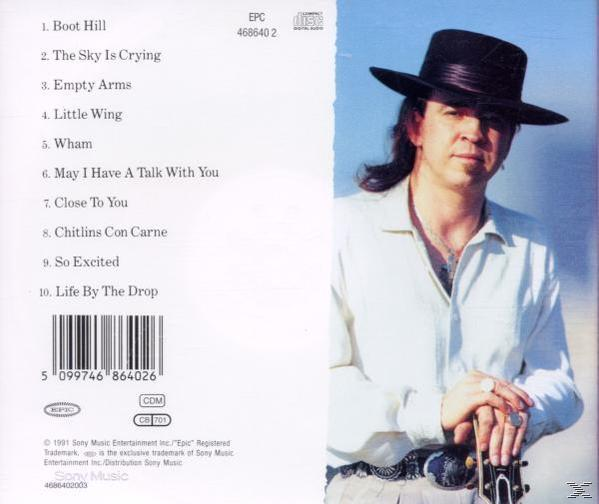 Albumcover mit Stevie Ray Vaughan. Er trägt einen Hut und hält eine Gitarre. Die Rückseite listet die Songs auf.