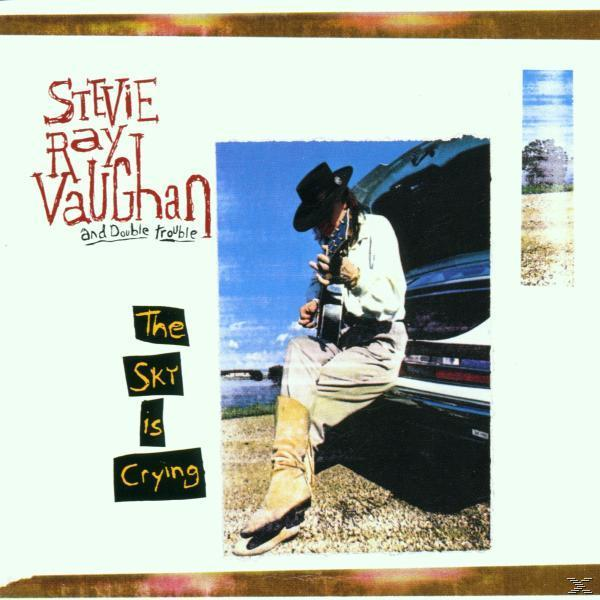 Albumcover mit Stevie Ray Vaughan, der Gitarre spielt, auf einem Auto sitzend. Der Text lautet 'The Sky Is Crying'.