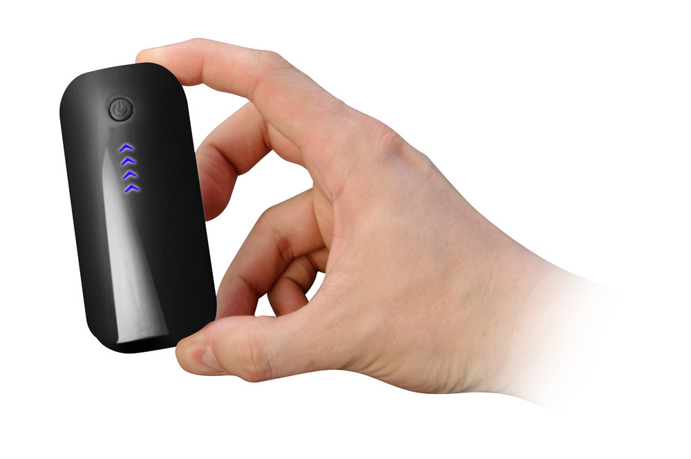 Hand hält ein schwarzes Gerät mit Strom- und Batteriestandsanzeigen auf weißem Hintergrund.