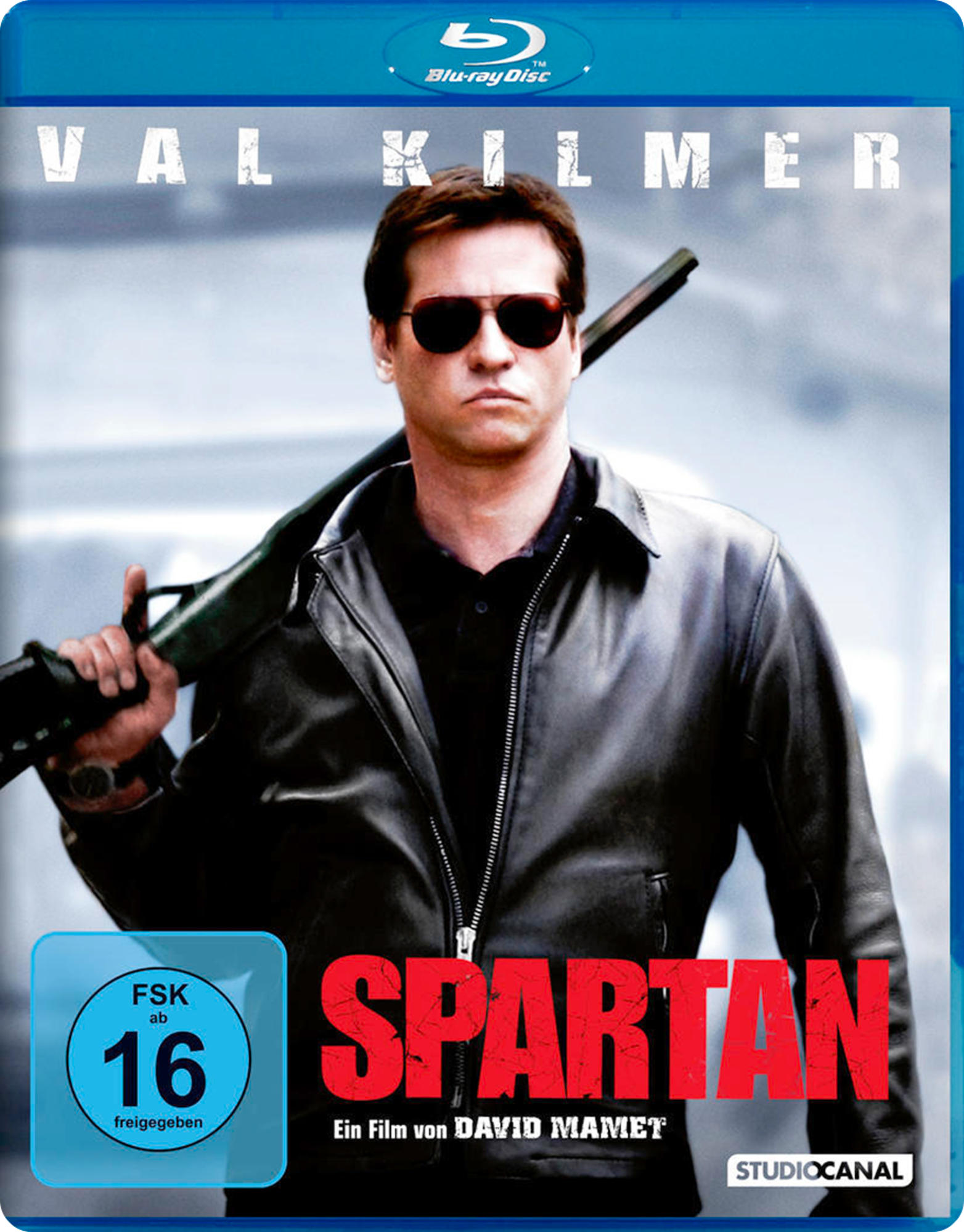 DVD-Cover des Films Spartan. Val Kilmer ist auf dem Cover und hält eine Waffe. Blu-ray Disc-Logo wird gezeigt.