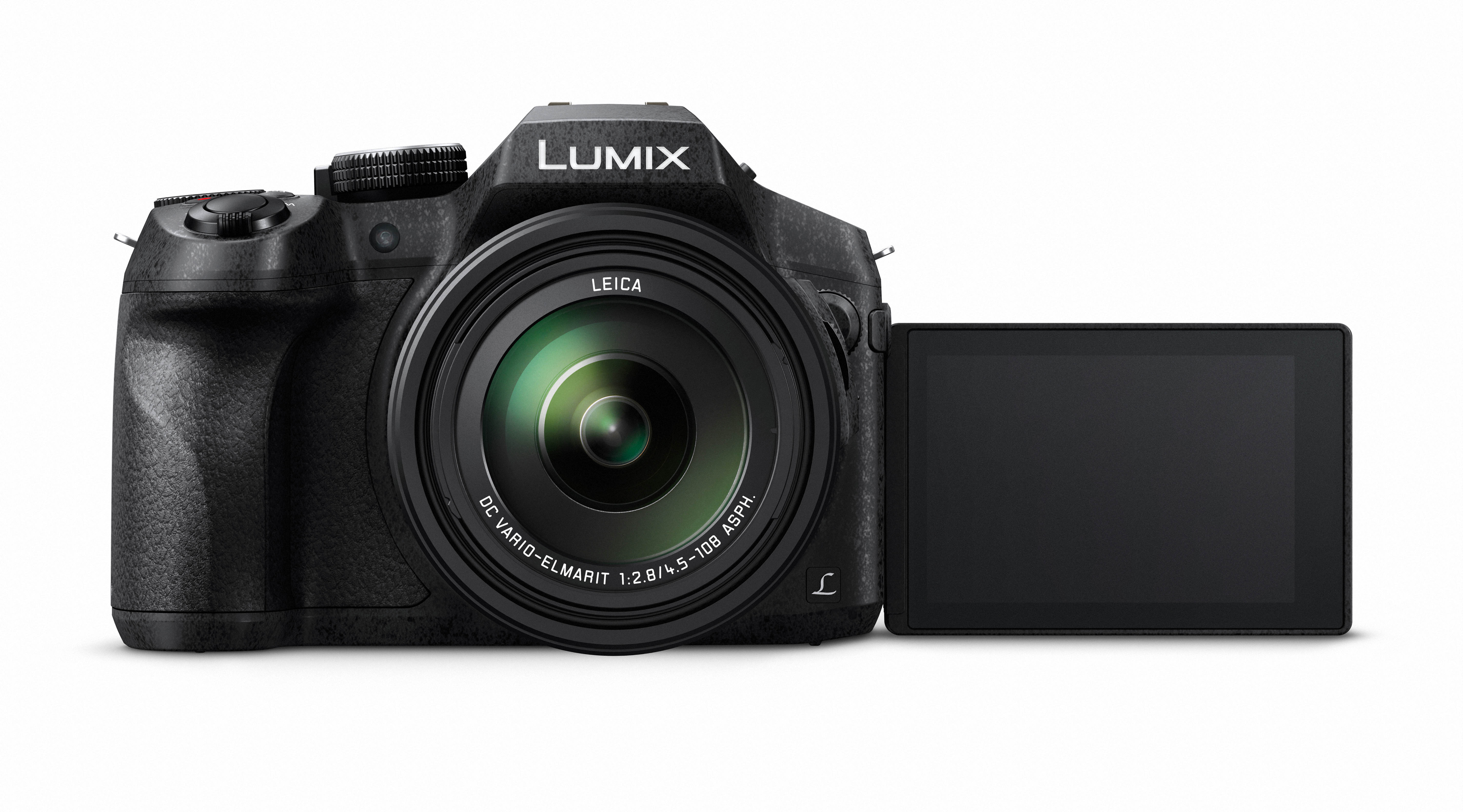 Una fotocamera nera con un obiettivo e uno schermo ribaltabile, su sfondo bianco.