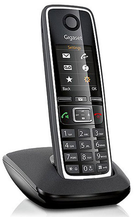 Şarj yuvasında siyah Gigaset kablosuz telefon, dijital ekranlı.