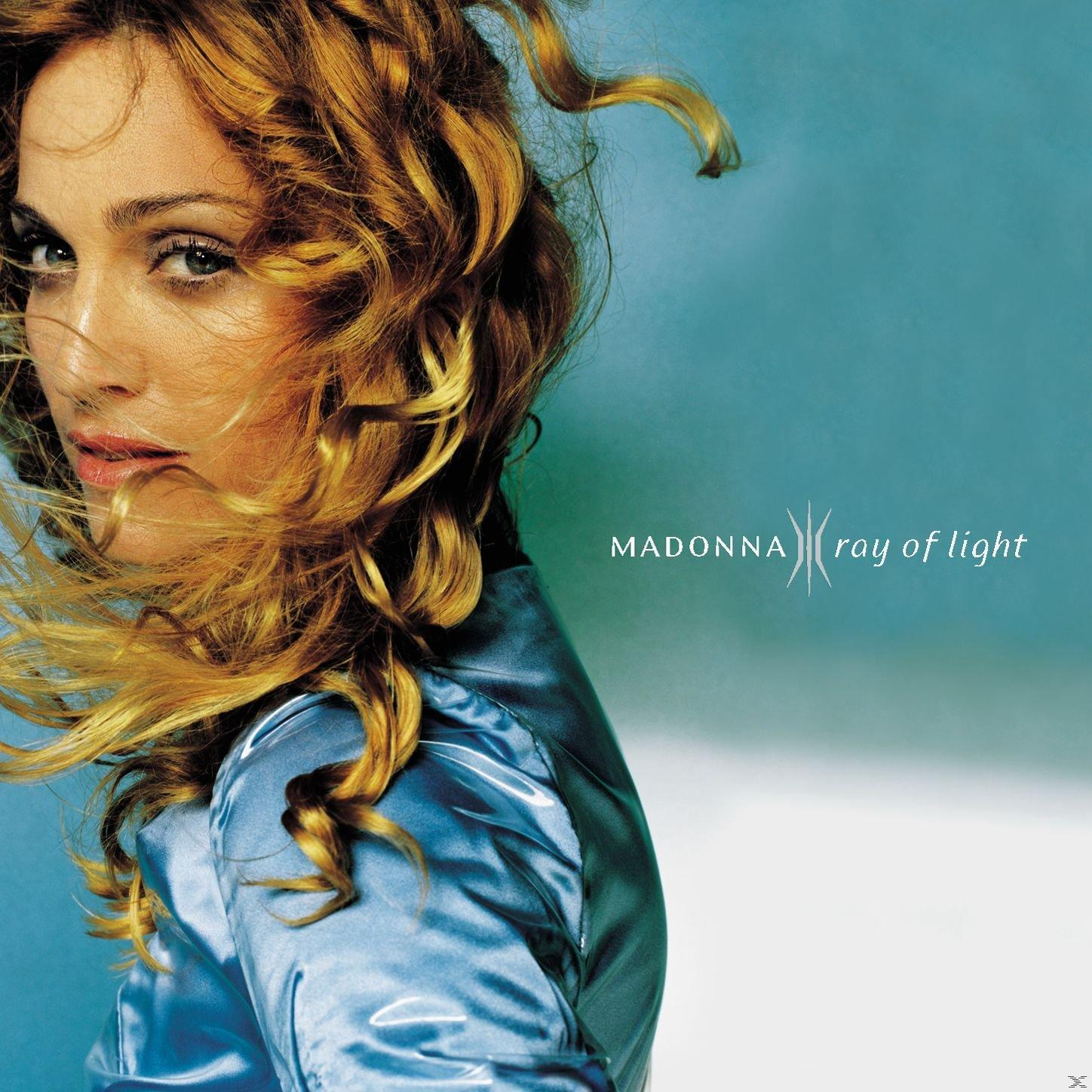 Albumcover: Madonna mit lockigem blondem Haar, trägt ein blaues Satin-Oberteil. Titel: Madonna Ray of Light.