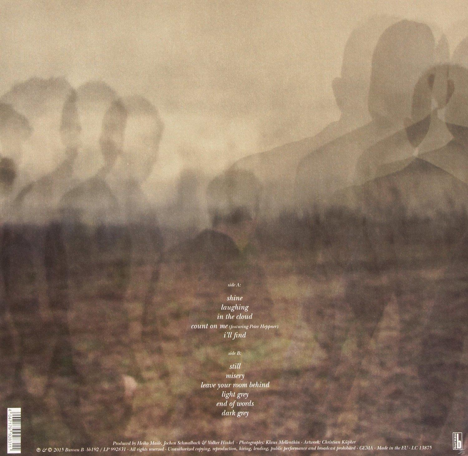 Album-Rückseite, verschwommene Silhouetten von Personen, Braun- und Beigetöne, und eine Trackliste.