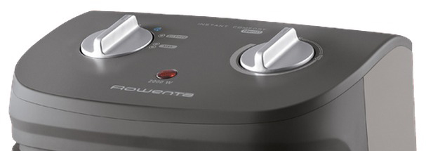 Close-up of a gray Rowenta heater. Two silver knobs, a red light, and the brand name are visible on the top panel.
