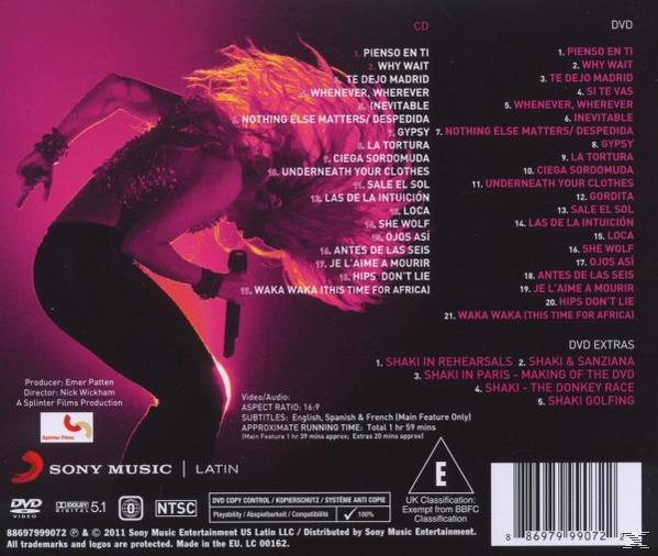 Shakira auf der Bühne mit rosa Lichtern, einem Mikrofon und einer CD-Trackliste.