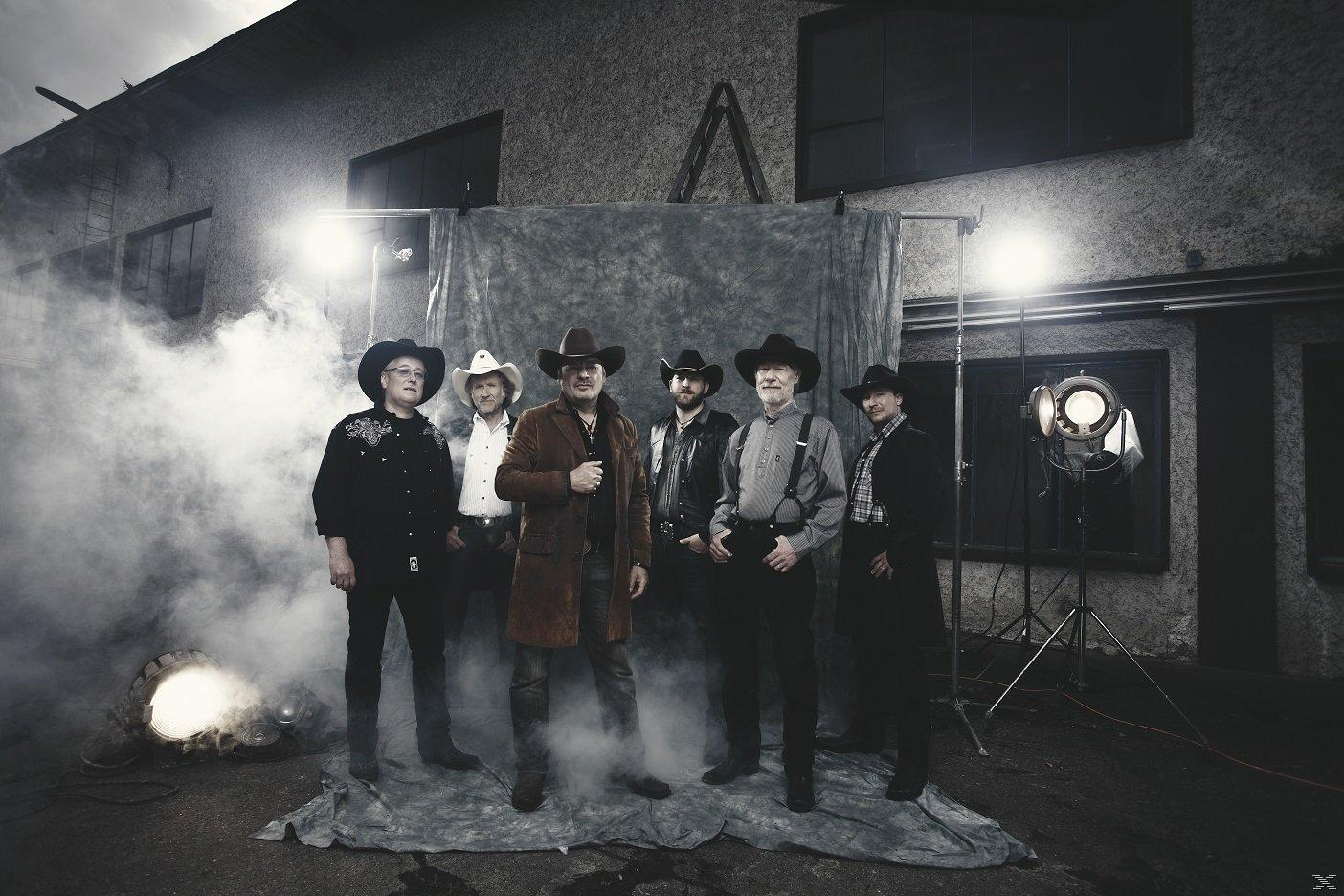 Männergruppe mit Cowboyhüten posiert vor einem Gebäude, Raucheffekt.