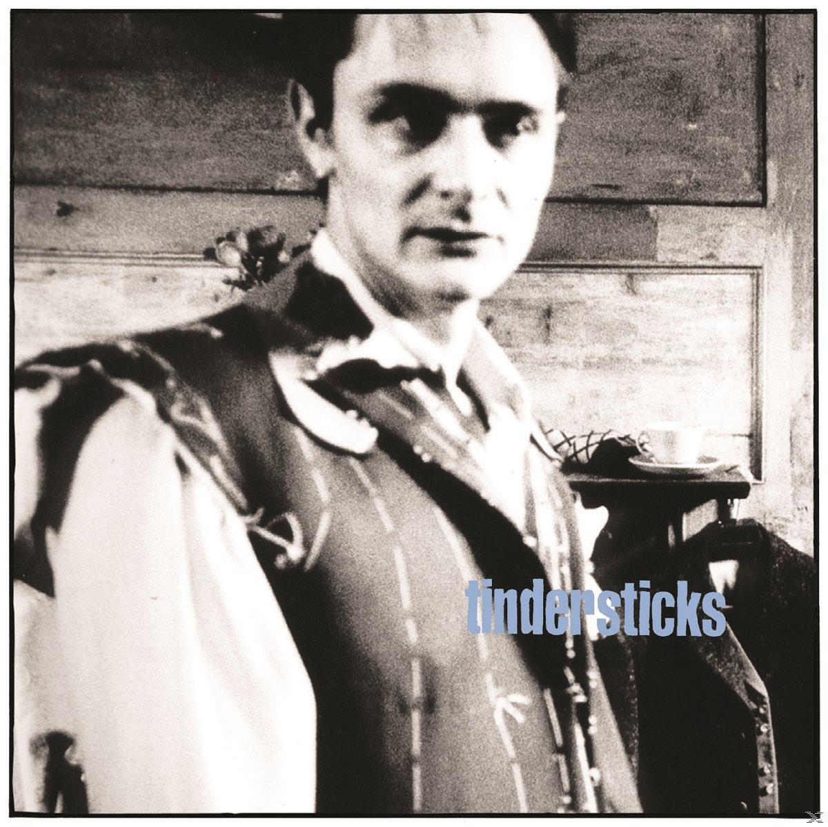 Fekete-fehér kép egy férfiról csíkos mellénnyel és fehér inggel. A tindersticks szó van írva.