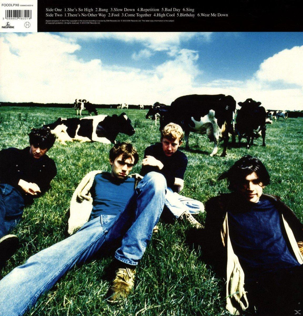 Bandmitglieder auf Gras mit Kühen im Hintergrund. Blauer Himmel. Text: Blur, Albumtitel und Titel.