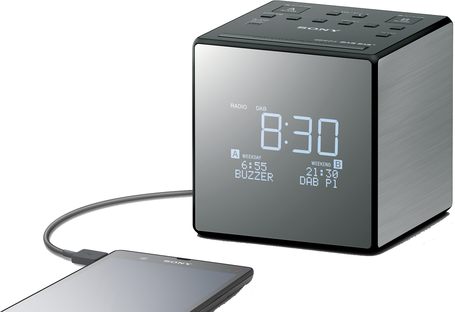 Black cube-shaped digital clock/radio. Displays time, day, and has a charging phone next to it.