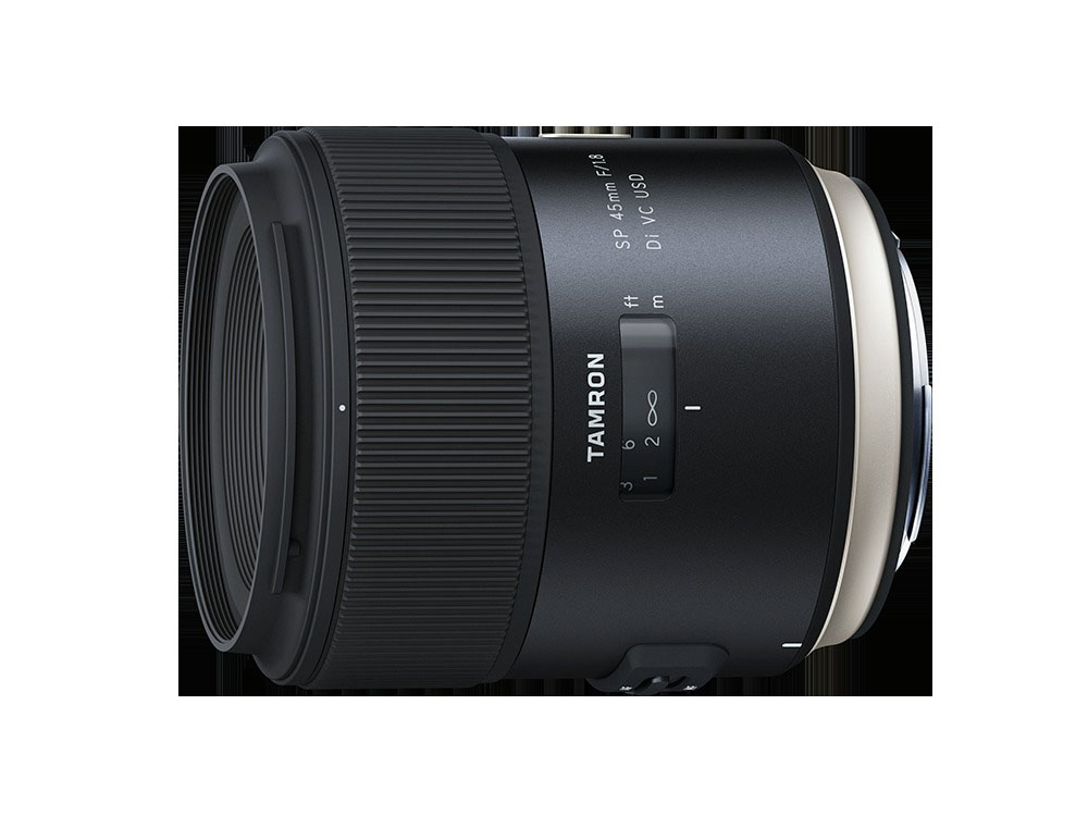 Ein schwarzes Kameraobjektiv, Tamron, mit Fokus- und Entfernungskennzeichnungen. Das Objektiv ist horizontal.
