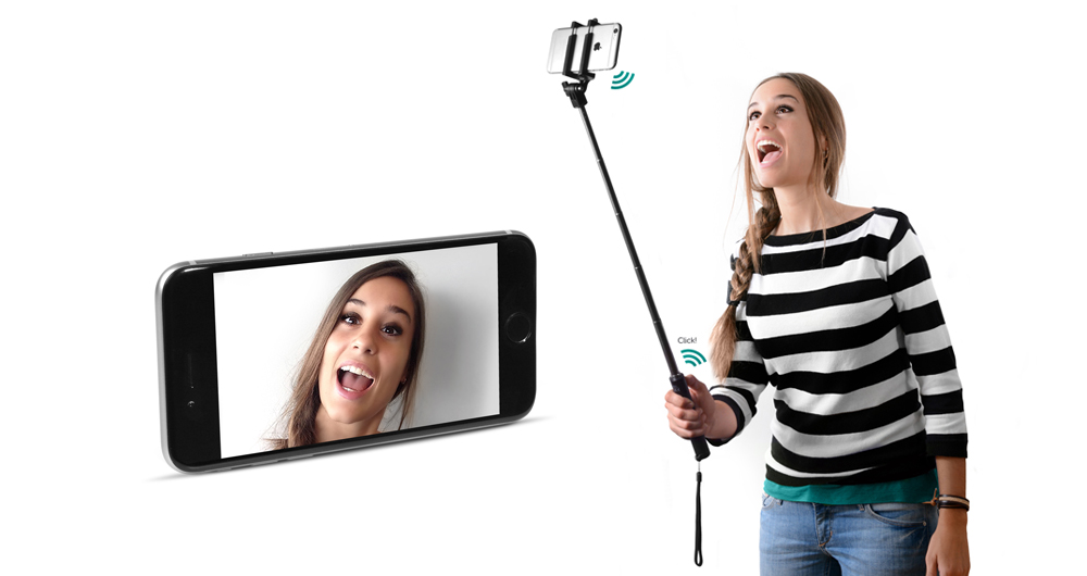Een vrouw die een selfie maakt met een telefoon op een selfiestick. Een andere telefoon toont haar gezicht.