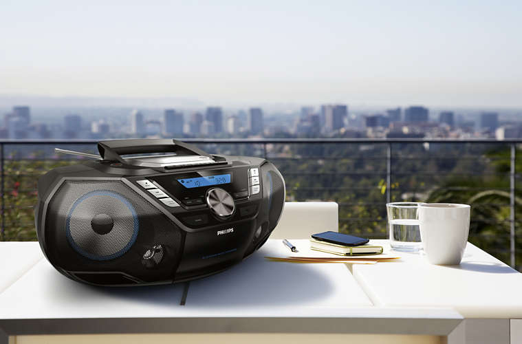 Boombox Philips noir sur une table blanche. Skyline en arrière-plan.