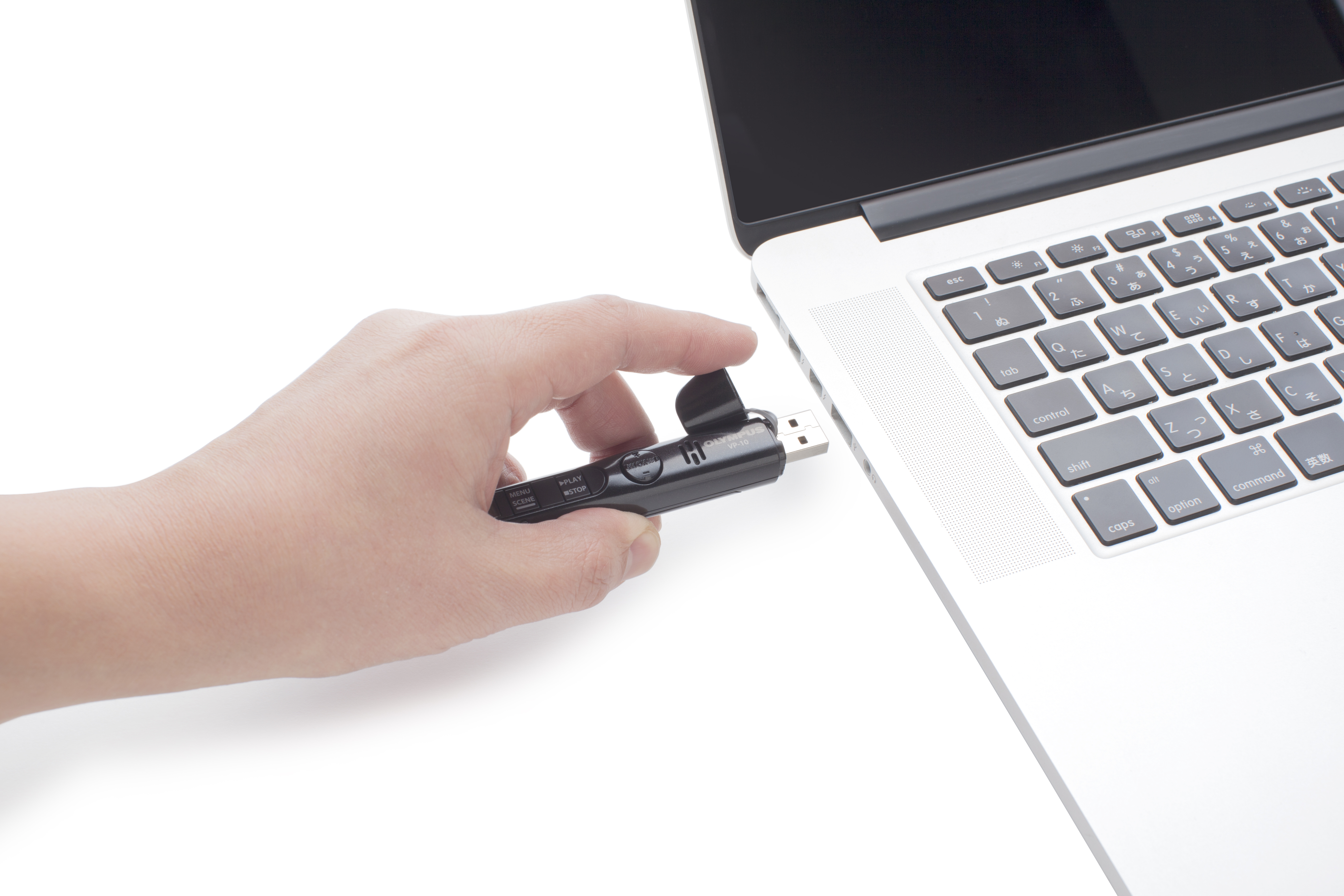 Hand, die einen USB-Stick in einen Laptop steckt.